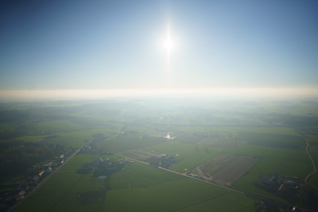 uitzicht op west-vlaamse en henegouwse landbouwvelden bij zonsopgang tijdens een comfortabele ballonvaart met airo
