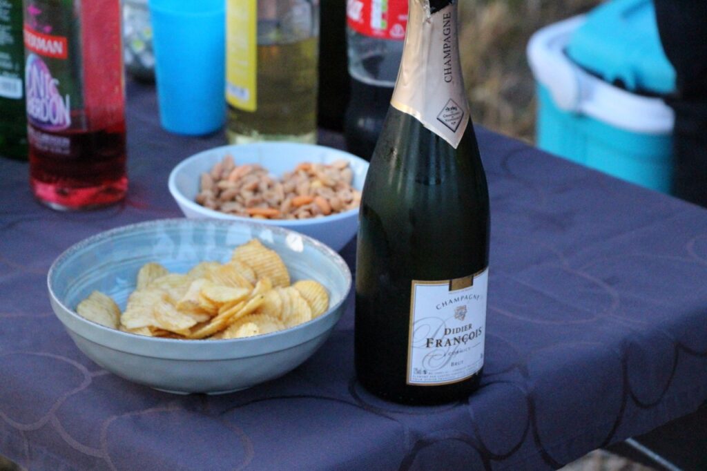 fles champagne met schaal chips en borrelhapjes op tafel bij airo ballonvaarten west-vlaanderen henegouwen