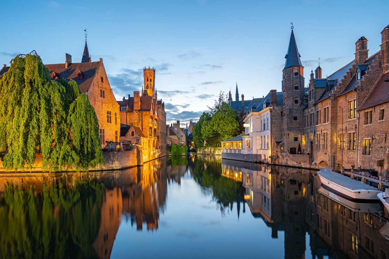 kanaal in bruges met middeleeuwse gebouwen en reflecties zonsondergang door Airo ballonvaarten