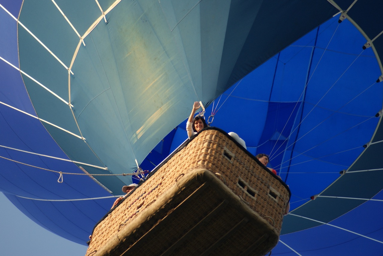 comfortabele ballonvaart met mand en passagiers onder blauw ballonzeil airo in west-vlaanderen en henegouwen