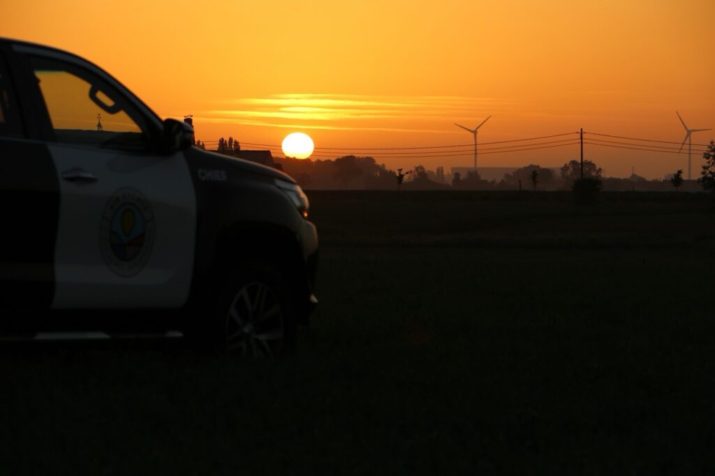 zwarte airo wagen bij zonsondergang in west-vlaanderen met windmolens op achtergrond