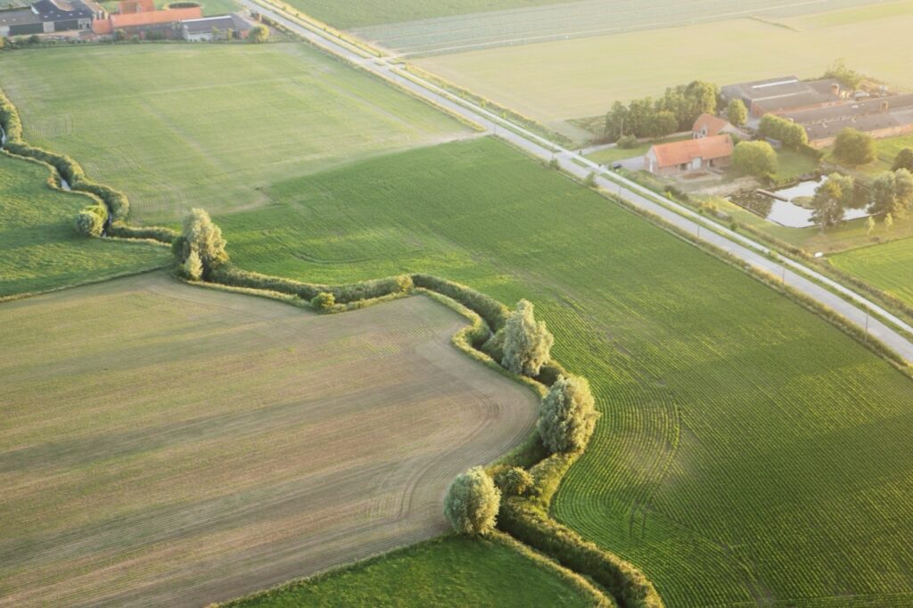 landschap met velden en boerderij vanuit vogelperspectief tijdens een ballonvaart met Airo in west-vlaanderen en henegouwen