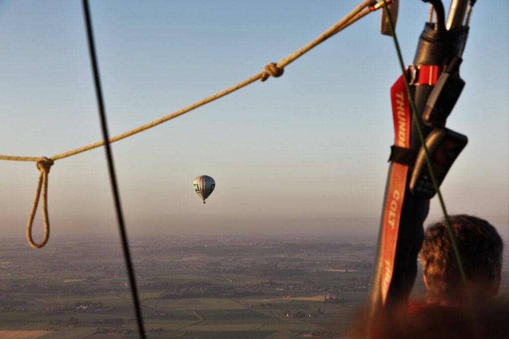 ballonvaart van airo met uitzicht op een zwevende heteluchtballon boven west-vlaanderen bij zonsondergang