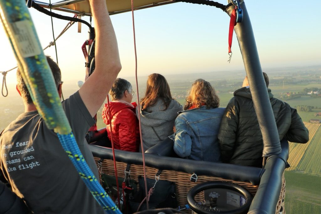 passagiers genieten van comfortabele ballonvaart in west-vlaanderen met Airo tijdens zonsondergang