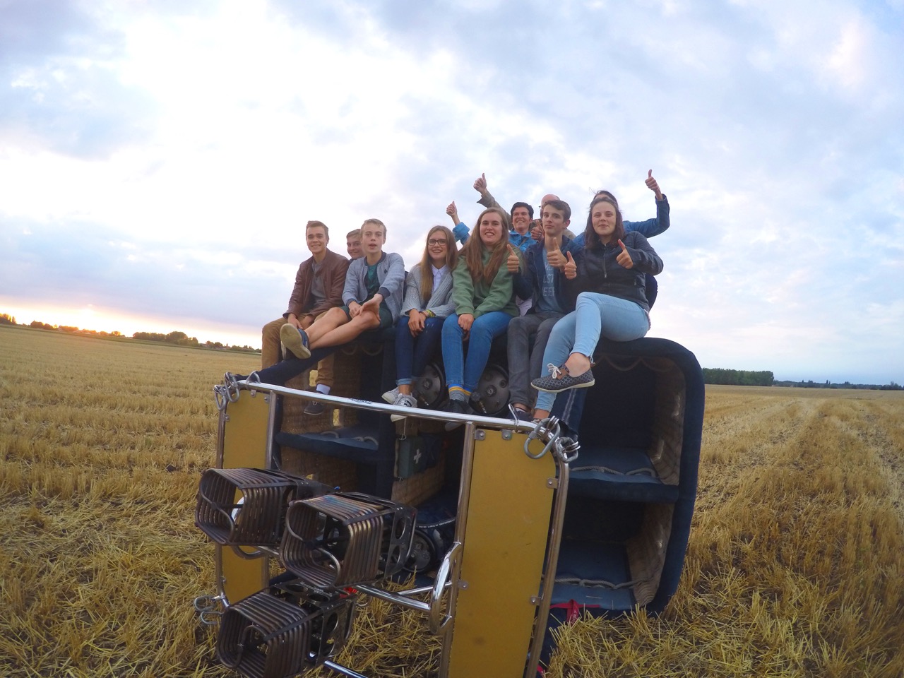 groep jongeren geniet van comfortabele ballonvaart met airo in west-vlaanderen en henegouwen op landing